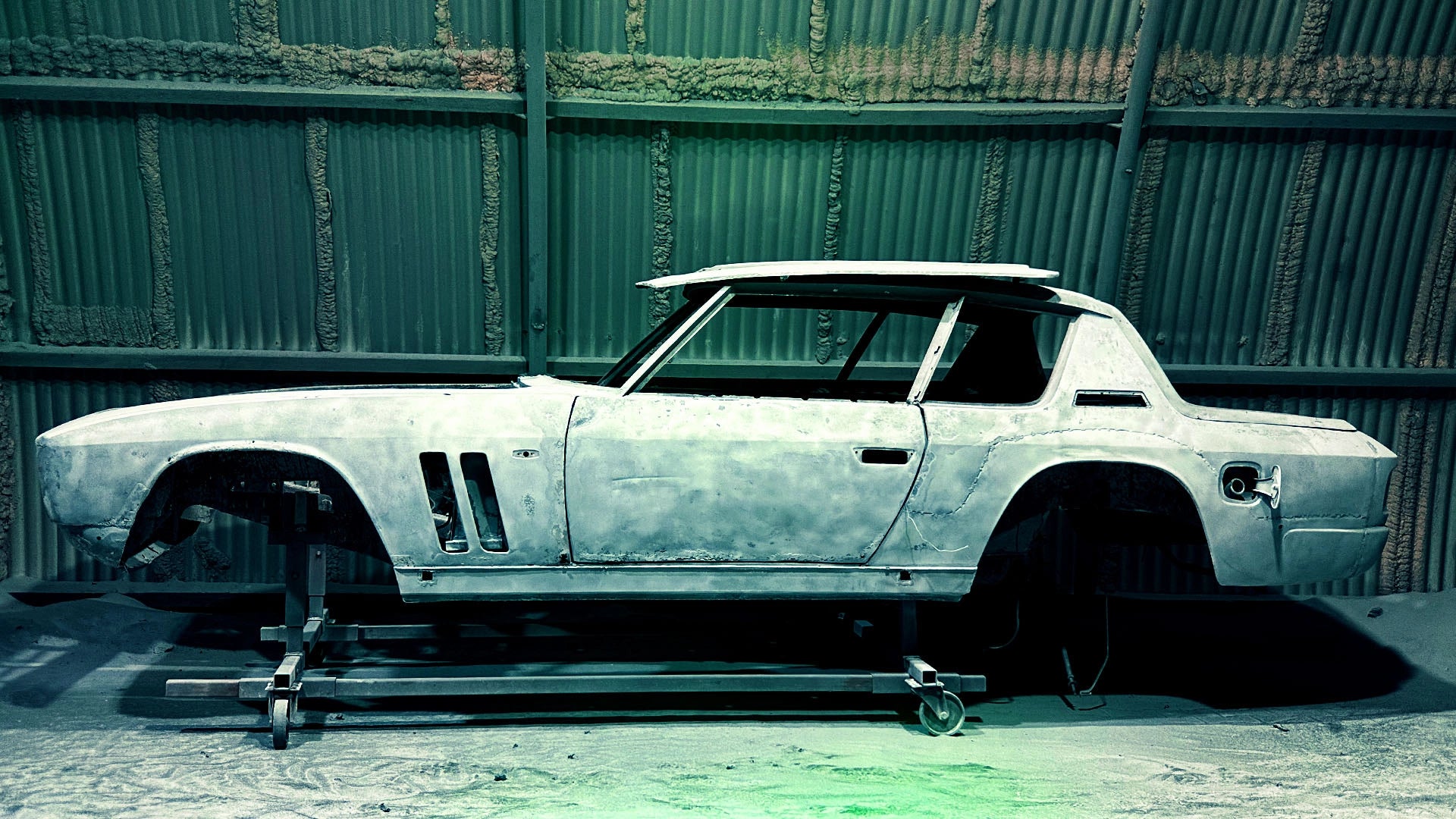 Sauberes Metall: Eine blankgestrahlte Jensen Interceptor Karosserie auf einem Rollgestell bei ecoBlast, Viersen – der ideale Ausgangspunkt für die Lackierung.