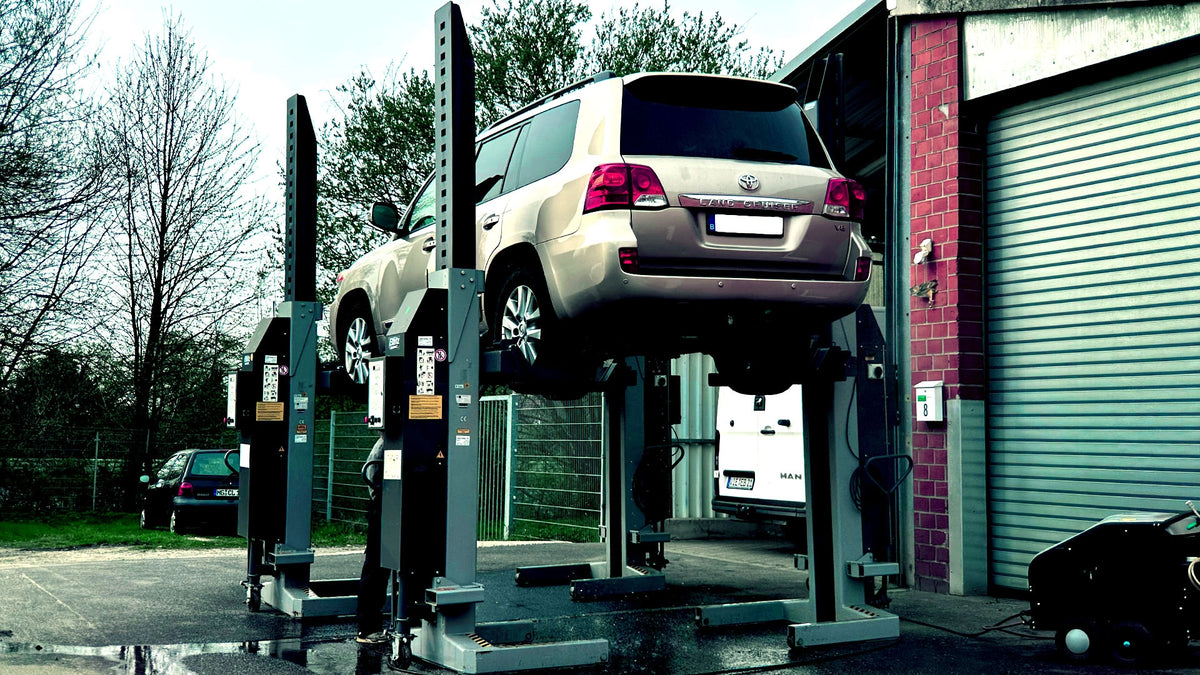 Toyota Land Cruiser V8 auf mobiler Radgreifer-Hebebühne bei ecoBlast Werkstatt.