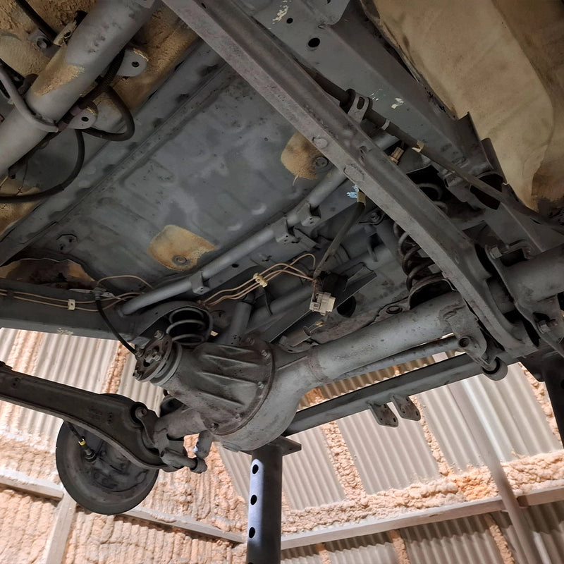 Ansicht eines professionell gereinigten Fahrzeugunterbodens bei der Firma ecoBlast in Nettetal. Das Bild zeigt das saubere Metall von Chassis, Differential und Aufhängung nach einer gründlichen Entrostung und Reinigung mittels Strahltechnik, bereit für die anschließende Konservierung.