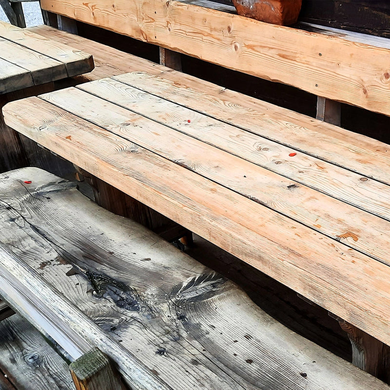 Effektive Holzreinigung und Restaurierung durch die Firma ecoBlast in Nettetal. Der direkte Vergleich zeigt einen hellen, sauber gestrahlten Holztisch neben einer noch grau verwitterten Sitzbank, was die gründliche und schonende Auffrischung von Holzoberflächen verdeutlicht.