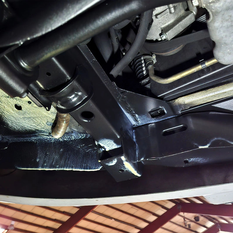 Detailaufnahme einer fachgerechten Unterbodenversiegelung durch die Firma ecoBlast in Nettetal. Das Bild zeigt den frisch beschichteten, glänzend schwarzen Fahrzeugrahmen und angrenzende Komponenten, die nach der professionellen Reinigung nun optimal und langfristig vor Korrosion geschützt sind.